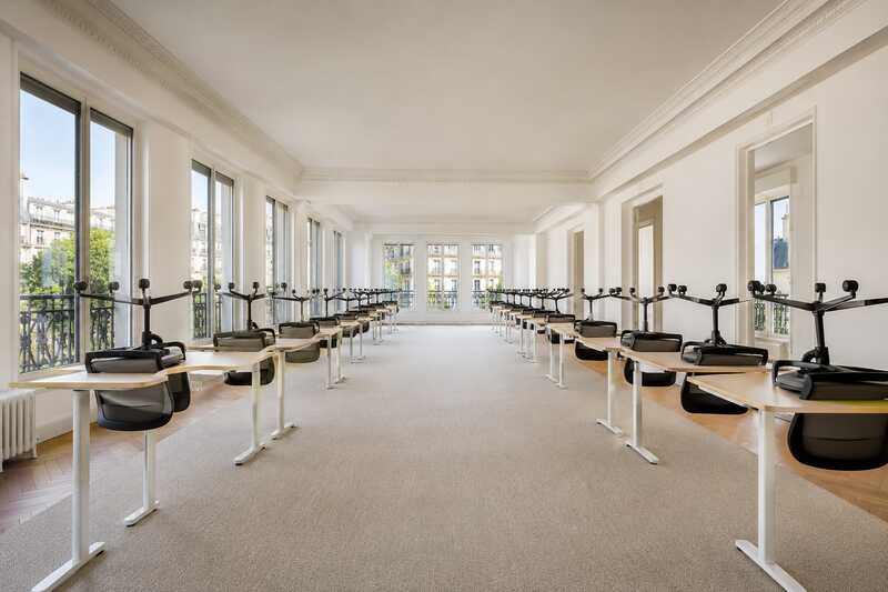 Plateau de bureaux vidé, chaises retournées sur les tables