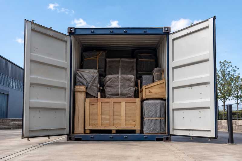 Conteneur maritime ouvert sur du mobilier housse et des caisses