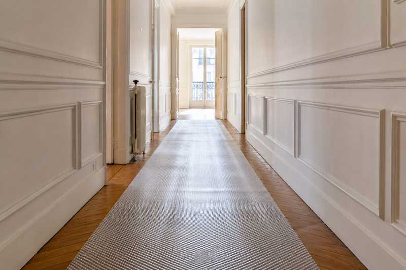 Protections de sol déroulées dans un couloir d’appartement vide