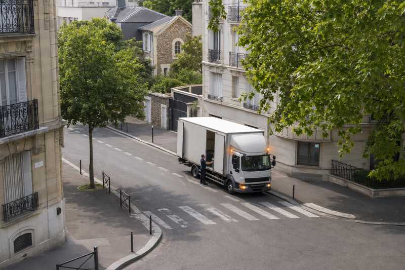 Camion à l’arrêt feux de détresse allumés à l’angle d’un carrefour