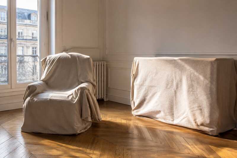 Fauteuil et commode protégés par des housses de tissu