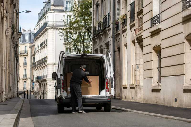 Utilitaire compact chargé dans une rue étroite