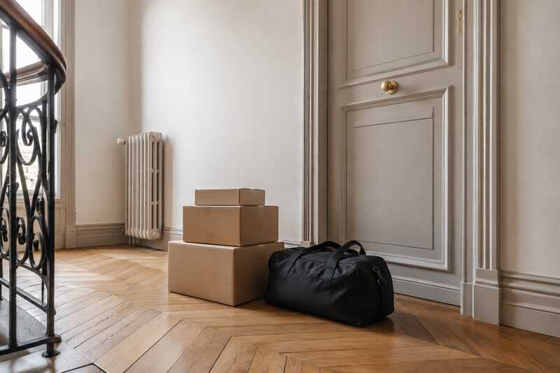 Cartons et sac de sport en attente sur un palier